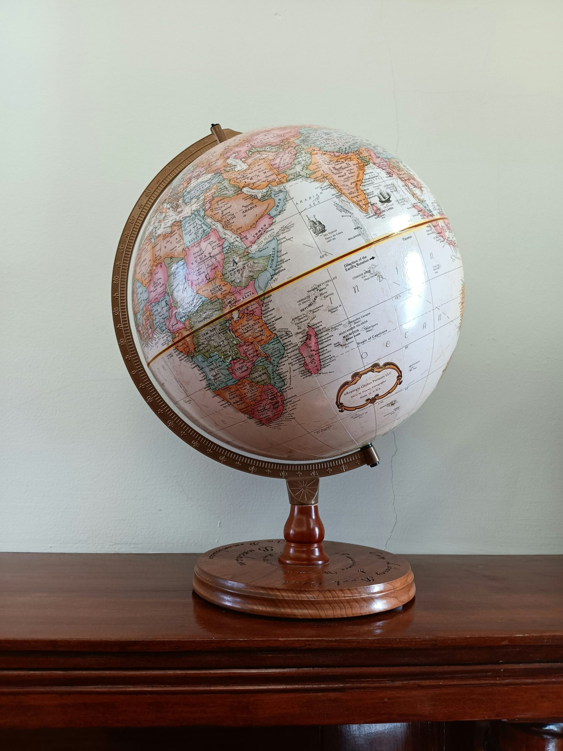 Un globe décoratif repose sur une table en bois.